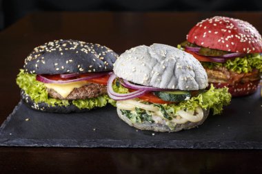 siyah arka planda çok renkli burgerler