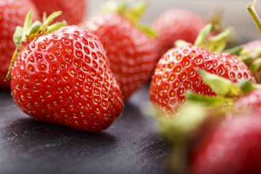 Siyah arka planda taze çilekler.