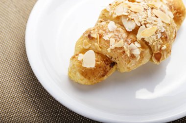 masanın üzerinde bir tabakta kruvasan