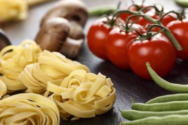 bir kayrak siyah tahta üzerinde sebze ile tagliatelli