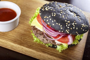 bir kesme tahtası üzerinde siyah burger