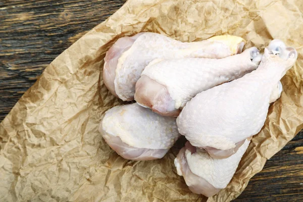 Cuisses de poulet crues sur papier artisanal — Photo