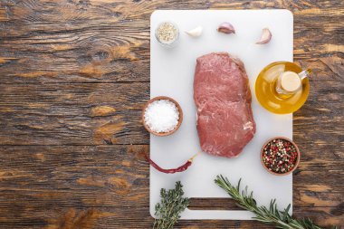 Ahşap arka planda çiğ biftek.