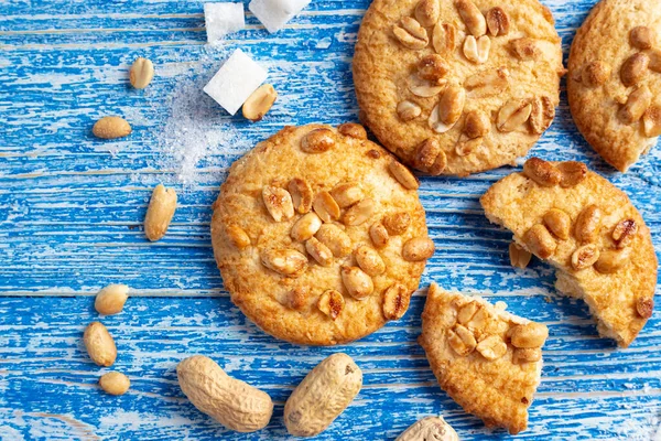 Yer fıstığı serpilmiş ev yapımı kısa hamurlu pasta. mavi ahşap bir sırtüstü dağılmış