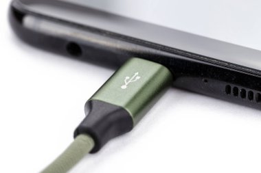 Mobil akıllı telefonlar beyaz arkaplanda şarj ediliyor.