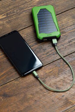 Tahtada elektrik bankasıyla çalışan akıllı telefon.