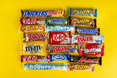 Ukrayna, Kyiv - 23 Mart 2020: Sarı arka planda Snickers, Twix, Milka, Kitkat, Lion, M & M, Bounty gibi çikolatalar.