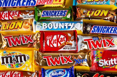 Ukrayna, Kyiv - 23 Mart 2020: Sarı arka planda Snickers, Twix, Milka, Kitkat, Lion, M & M, Bounty gibi çikolatalar.