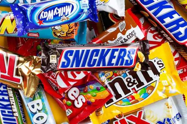 Ukrayna, Kyiv - 23 Mart 2020: Sarı arka planda Snickers, Twix, Milka, Kitkat, Lion, M & M, Bounty gibi çikolatalar.