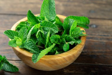 Tahta masadaki kasede yeşil taze nane, seçici bir odak..