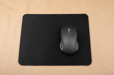 Fare altlığında siyah kablosuz fare, üst görünüm.