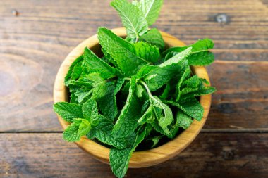 Tahta masadaki kasede yeşil taze nane, seçici bir odak..