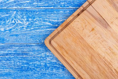 Mavi arka planda dikdörtgen kesim tahtası. Yukarıdan görüntüle.