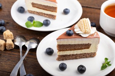 Masada kremalı kek var. Yaban mersinli pastanın yanında.