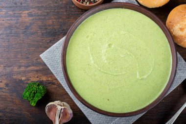 Masadaki tabakta yeşil sebze kremalı brokoli. Yanında taze çörekler ve Borkcol 'ün cilvesi var.