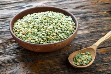 Ahşap bir masada kil tabakta yeşil kuru bezelyeler. tex için yer