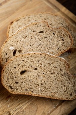 Köy ahşap bir masada taze ekmek ve dilimlenmiş ekmek..