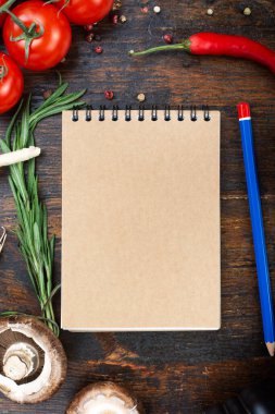 Sebze ve kağıttan bir defter sarmal üzerinde, kahverengi ahşap bir arka planda. tex için yer