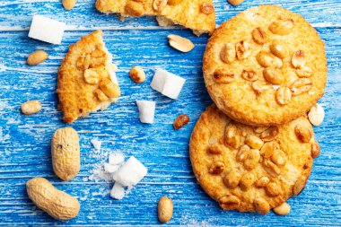 Yer fıstığı serpilmiş ev yapımı kısa hamurlu pasta. mavi ahşap bir sırtüstü dağılmış