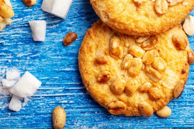 Yer fıstığı serpilmiş ev yapımı kısa hamurlu pasta. mavi ahşap bir sırtüstü dağılmış