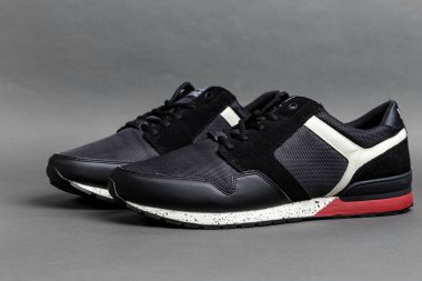 Koyu gri arka planda bir çift siyah spor ayakkabı. rahat rahat ayakkabılar ve spor ayakkabıları