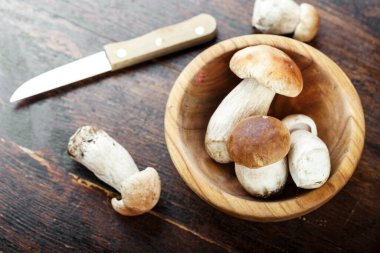 Tabaktaki çiğ mantarlar kahverengi ahşap arka planda. tex için yer