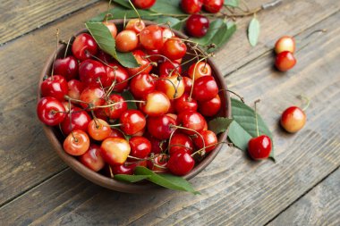 Tahta masada taze kiraz meyvesi ve yaprak..