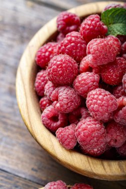 Tahta arka planda ahududu, basit bir ahşap tabakta. organik yaz cro