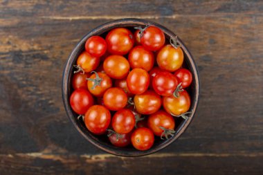 Ahşap bir zeminde kırmızı kiraz domatesleri. tex için yer