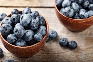 Kahverengi ahşap arka planda kil tabakta olgun yabanmersini. tex için yer