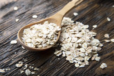 Kahverengi ahşap arka planda kaşık içinde pişmemiş yulaf ezmesi. tex için yer