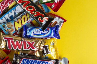 Ukrayna, Kyiv - 23 Mart 2020: Sarı arka planda Snickers, Twix, Milka, Kitkat, Lion, M & M, Bounty gibi çikolatalar.