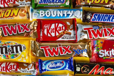 Ukrayna, Kyiv - 23 Mart 2020: Sarı arka planda Snickers, Twix, Milka, Kitkat, Lion, M & M, Bounty gibi çikolatalar.