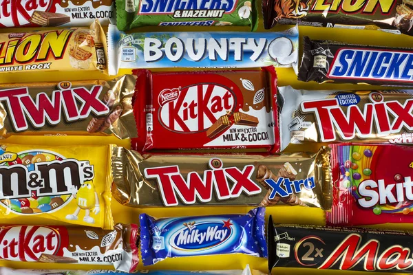 Ukrayna, Kyiv - 23 Mart 2020: Sarı arka planda Snickers, Twix, Milka, Kitkat, Lion, M & M, Bounty gibi çikolatalar.