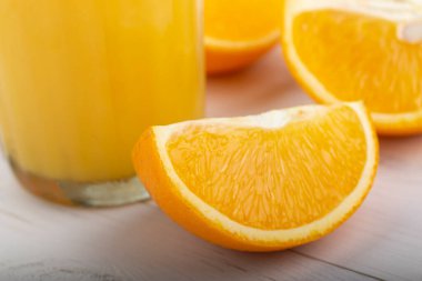 Beyaz bir masada taze portakal suyu. Dilimlenmiş narenciye meyvesi.