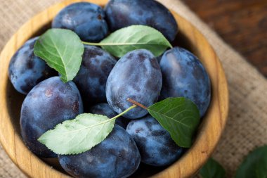 Tahta masadaki bir tabakta tatlı erikler. Sağlıklı meyve.