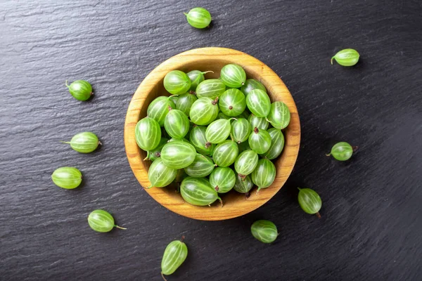 Tahta kasede taze bektaşi üzümü ve siyah taş kaplama arka plan. Üst görünüm.