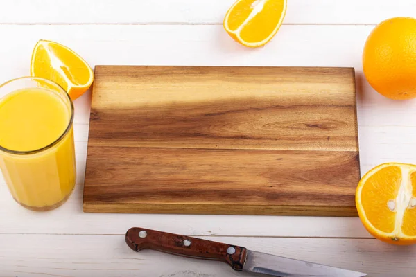 Beyaz bir masada taze portakal suyu. Dilimlenmiş narenciye meyvesi.