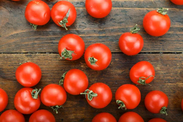 ripe cherry tomatoes on a brown wooden table. simple rustic backgroun