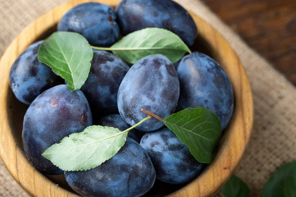 Tahta masadaki bir tabakta tatlı erikler. Sağlıklı meyve.
