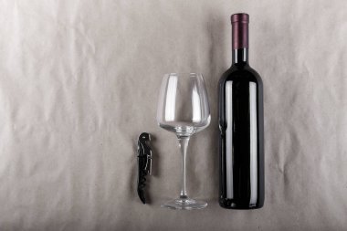 Kırmızı şarap şişesi ve arka planda cam..