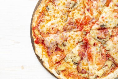 Ahşap arka planda, ahşap tabakta servis edilen lezzetli pizza. Üst Manzara. Metin için boşluk.