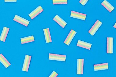 Mavi arka planda bir sürü renkli jöle şekeri. Metin için boşluk.