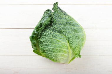 Beyaz ahşap arka planda Savoy lahanası.