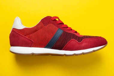 Sarı arka planda kırmızı spor ayakkabılar..