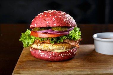 Kırmızı burger, pirzola ve tahta kesme tahtasında sebze. tex için yer