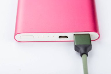 Mobil cihazları şarj etmek için güç bankası. Pembe akıllı telefon şarj aleti ve elektrik bankası. Batarya. Beyaz arkaplandaki mobil aygıtlar için dış pil.