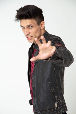 Beyaz arka planda deri ceketli etkileyici bir adam. Stüdyoda fotoğraf, dikey fotoğraf.