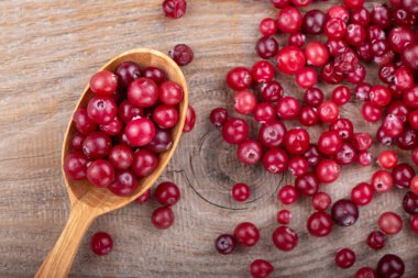 Tahta kaşıkta olgun kızılcıklar. Sağlıklı gıda konsepti.