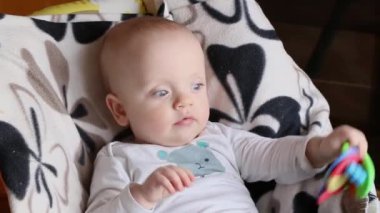 Plastik kemirgenli bebek sandalyede oturuyor..